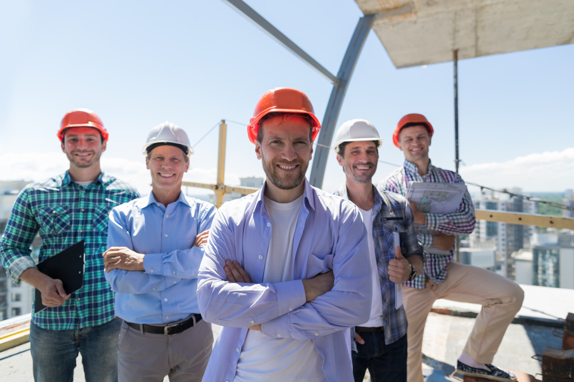 Builders Team Leader Over Group Of Apprentices At Construction Site, Happy Smiling Engineers